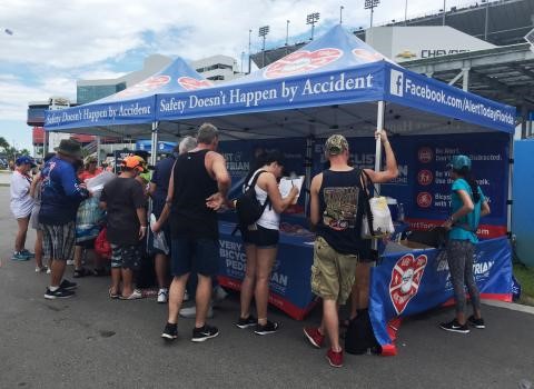 People stand in front of a blue pop-up tent.